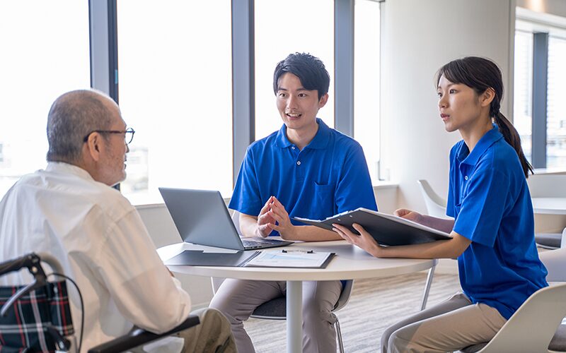 介護士と老人が相談している写真
